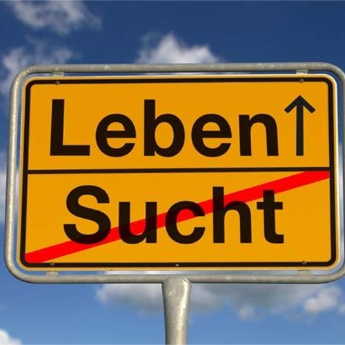 Verkehrsschild mit den Wörtern "Leben" und "Sucht" vor blauem Himmel.